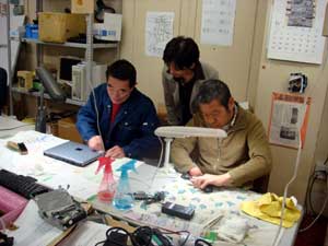 写真：リサイクル工房「サラエ」の再生作業を見学する菅波さん