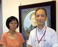 写真：手で触る絵_点字創始者ルイ・ブライユの肖像画の前で竹下副理事長と正井さん